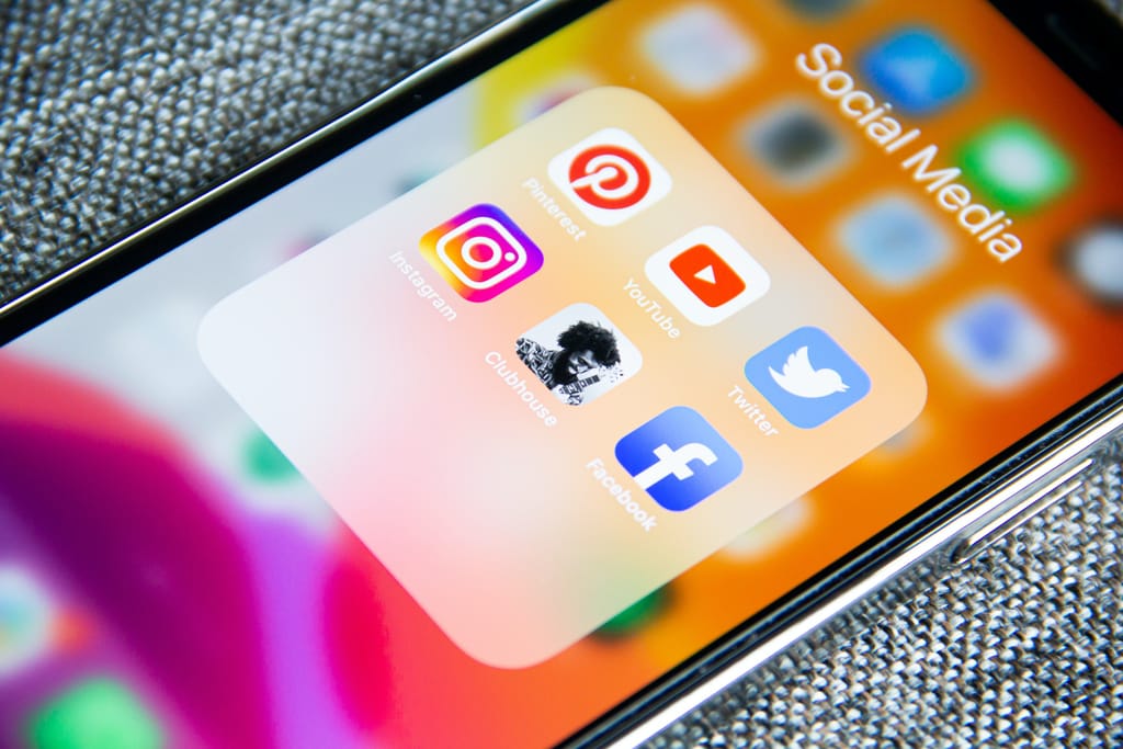 A smartphone displaying social media icons, including Pinterest, YouTube, Twitter, Instagram, Clubhouse, and Facebook. These are all effective performance marketing channels. 