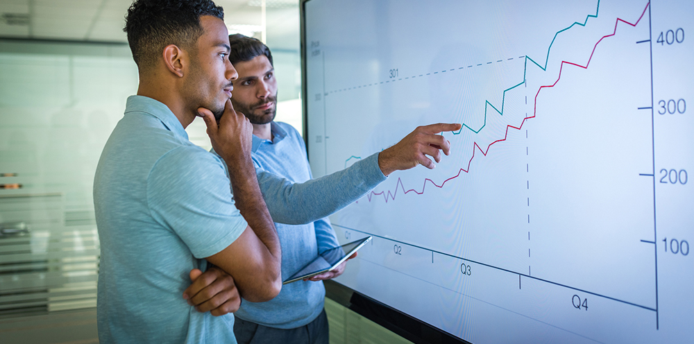 two men looking at line graph